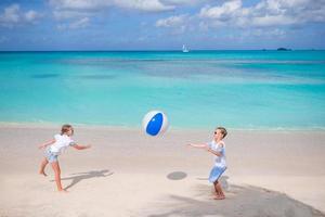 petites filles adorables jouant au ballon sur la plage photo