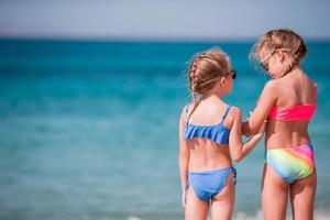 deux petites filles heureuses s'amusent beaucoup à la plage tropicale en jouant ensemble photo