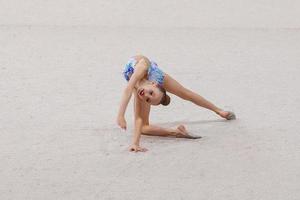 belle petite fille gymnaste active avec sa performance sur le tapis photo