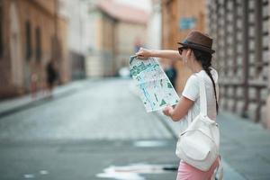 heureuse jeune femme au chapeau dans la rue de la ville européenne. photo