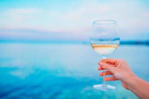 verre de vin blanc sur la plage tropicale photo