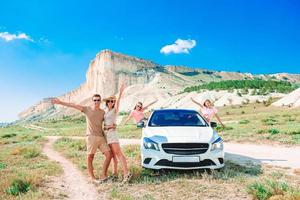 famille heureuse de quatre personnes marchant dans les montagnes photo