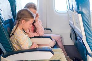 adorables petites filles voyageant en avion. photo