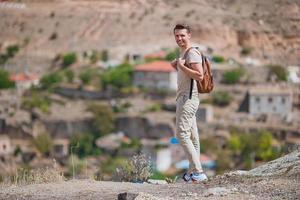 heureux jeune homme en randonnée au sommet de la colline photo