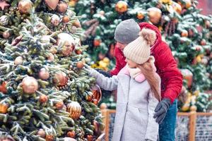 petite fille heureuse près de la branche de sapin dans la neige pour le nouvel an. photo