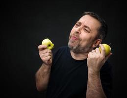 homme d'âge moyen avec des pommes vertes photo