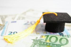 chapeau d'écart de graduation sur l'argent des billets en euros et en dollars américains, frais d'étude de l'éducation apprentissage enseigner le concept. photo