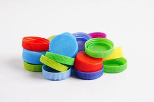 bouchons de bouteilles en plastique colorés pour recyclage sur fond blanc. photo