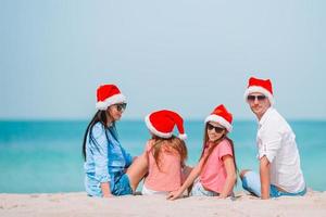 famille heureuse avec deux enfants en bonnet de noel en vacances d'été photo