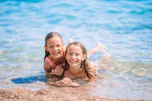 adorables petites filles s'amusant sur la plage photo