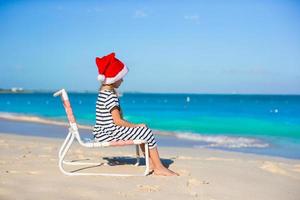 petite fille adorable portant un bonnet de noel à la plage des caraïbes photo