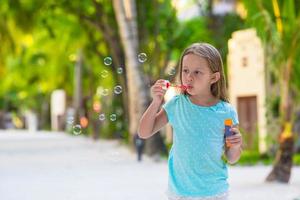adorable petite fille faisant des bulles de savon pendant les vacances d'été photo