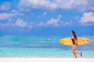 Belle surfeuse surfant pendant les vacances d'été photo