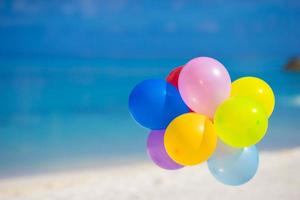 ballons multicolores sur la plage tropicale blanche photo