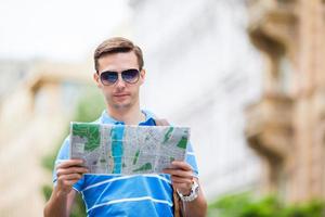touriste caucasien marchant le long des rues désertes de l'europe. jeune garçon urbain en vacances explorant la rue pavée de la ville européenne photo