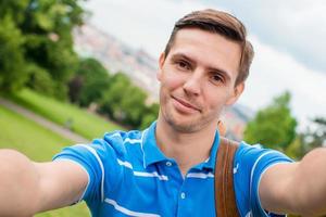 jeune homme caucasien faisant selfie arrière-plan vieille ville européenne par téléphone portable depuis le lieu d'observation photo