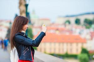 fille touristique prenant des photos de voyage par une célèbre attraction avec smartphone pendant les vacances d'été. jeune touriste attrayant prenant une photo avec un téléphone portable à l'extérieur profitant d'une destination de voyage de vacances dans le tourisme et explorant le concept