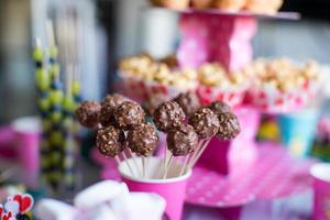 Cakepops au chocolat sur la table des desserts de vacances à la fête d'anniversaire des enfants photo