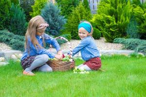 deux petites filles heureuses avec une grande récolte d'automne de tomates dans des paniers photo