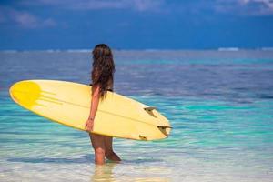 Belle surfeuse surfant pendant les vacances d'été photo