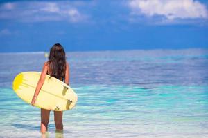 Belle surfeuse surfant pendant les vacances d'été photo