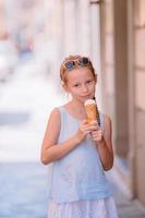 adorable petite fille mangeant des glaces à l'extérieur en été. photo