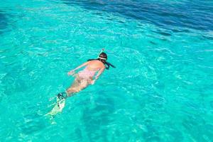 jeune femme plongée en apnée dans l'eau tropicale en vacances photo