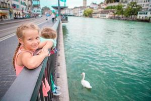 adorables petites filles à l'extérieur à zurich, en suisse. enfants dans une belle ville près de la rivière et des cygnes photo