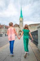 adorables petites filles de mode à l'extérieur à zurich, en suisse. deux enfants marchant ensemble dans la ville européenne. photo