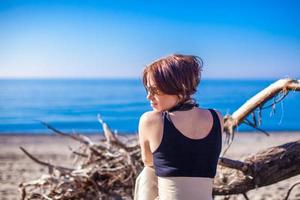 belle jeune femme se détendre sur la plage en hiver journée ensoleillée seule photo