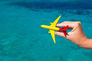 petit avion fait maison dans une main féminine sur fond de mer photo