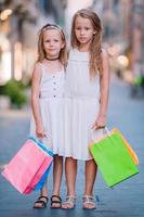 jolies petites filles souriantes avec des sacs à provisions photo