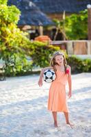 petite fille adorable jouant au volley-ball sur la plage avec ballon. famille sportive profiter du jeu de plage à l'extérieur photo