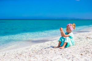 petite fille adorable prendre une photo de la mer au téléphone à la plage tropicale