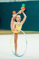 belle petite fille gymnaste active avec sa performance sur le tapis photo