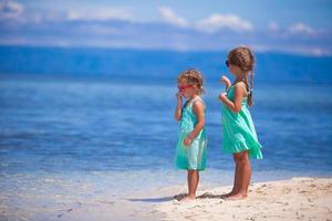 petites filles adorables sur la plage blanche regardent la mer photo