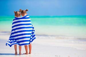 adorables petites filles enveloppées dans une serviette à la plage tropicale photo