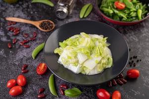 chou sauté sur une plaque noire avec des tomates photo