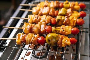 barbecue avec une variété de viandes, tomates et poivrons