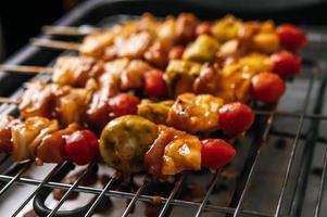 barbecue avec une variété de viandes, tomates et poivrons