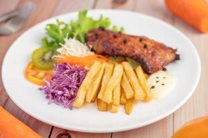 steak de poisson avec frites, fruits et légumes photo