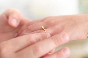 plaçant une bague de fiançailles à son doigt photo