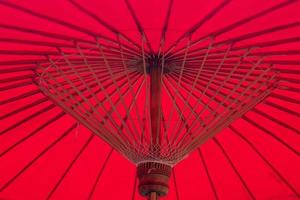 sous le parapluie rouge. structure en bambou. idée de fond asiatique photo