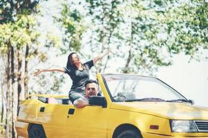 couple heureux profitant du toit en cabriolet photo