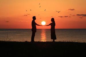 silhouette d'un couple au coucher du soleil photo