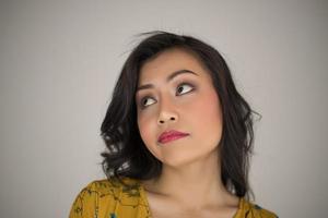 jeune femme fait une expression faciale sur fond blanc photo