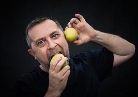 homme d'âge moyen avec des pommes vertes photo