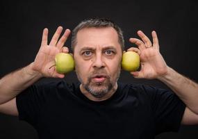 homme d'âge moyen avec des pommes vertes photo