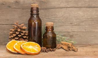 flacon aux huiles naturelles d'orange, de pin et de cannelle. concept d'aromathérapie et de cosmétiques naturels photo