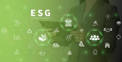 concept d'entreprise d'investissement de gouvernance sociale environnement esg. les femmes utilisent un ordinateur pour analyser l'esg, entouré d'icônes esg. près de l'écran d'ordinateur dans le concept de stratégie d'investissement des entreprises. photo